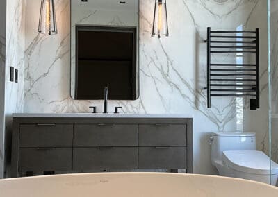 Sconce style lamps installed in a marbled walled bathroom